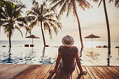 Holidays, tourist relaxing in luxury beach hotel near luxurious swimming pool.