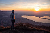 Hiker looking sun over horizon