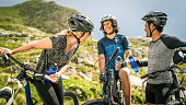 Cycling family having fun during a water break in the mountains