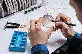 Closeup of man's hands marking lens for eyeglasses