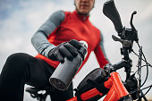 Male cyclist taking a bottle of water