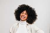 Happy young woman of color smiling at the camera in a studio