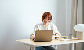 Smiling Young Woman Studying Online On A Laptop Computer At Home