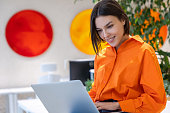 Joyous lady working on the laptop in the modern office