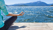 Woman practicing yoga by the sea.