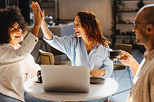 Successful business team high fiving in a coffee shop