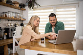 Young man is using a laptop in the kitchen