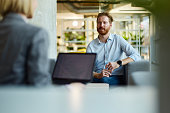 Redhead businessman talking to his colleague at casual office.