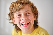 Happy boy with freckles on light background