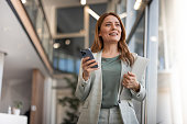 Smiling businesswoman using phone in office