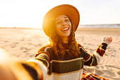 Young woman posing by the sea at sunset.