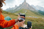 Woman brewing alternative coffee sitting with view of Passo Giau in Dolomites