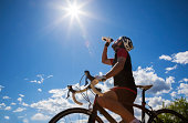 Cyclist resting and drinking isotonic drink.