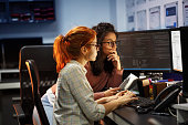 Two female programmers working on new project.They working late at night at the office.