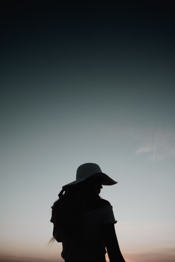 Silhouette of a Woman at Sunset by The Sea Free Photo