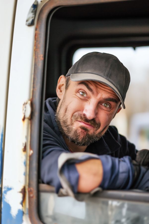 Truck Driver Making Faces Out of the Truck Window Free Image