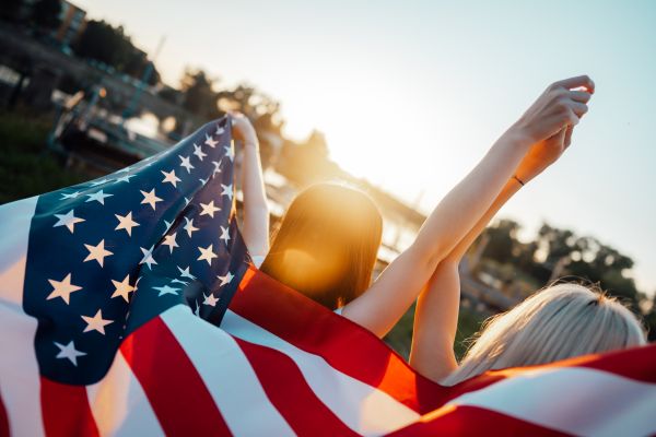 Two Happy Women Walking with USA Flag on Independence Day Free Photo