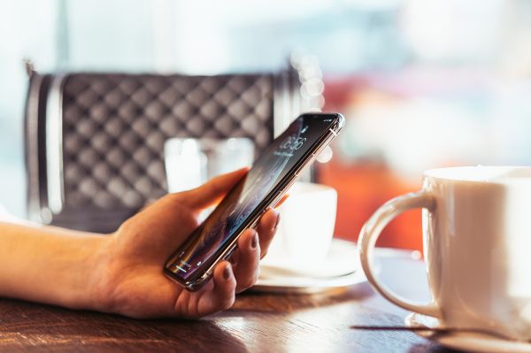 Woman Holding Modern Smartphone in Hand Free Photo